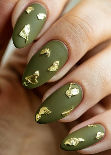 Elegant matte olive green nails with gold foil accents for a chic, modern manicure.