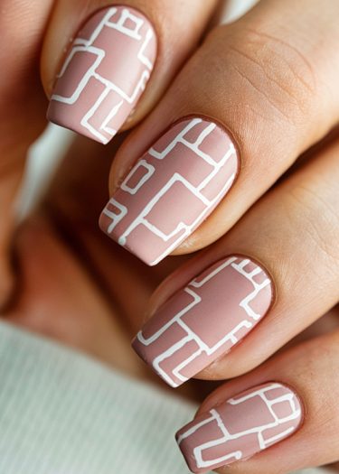 Elegant matte pink geometric nail art with intricate designs for a modern manicure.