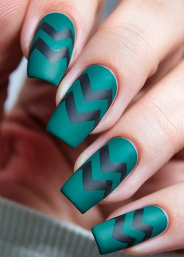 Elegant teal matte nails with black zigzag patterns for trendy nail art inspiration.