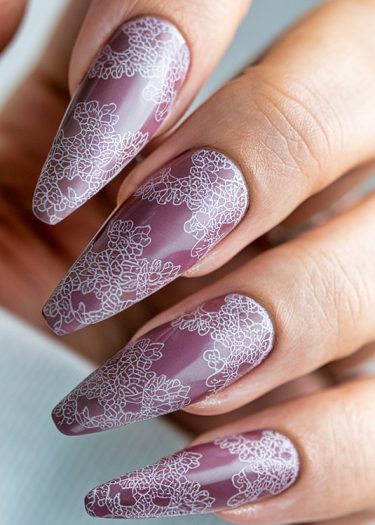 Elegant mauve nails featuring intricate white lace designs for a chic manicure look.