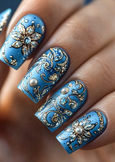 Luxurious metallic blue and gold nail art with intricate designs and sparkling embellishments.