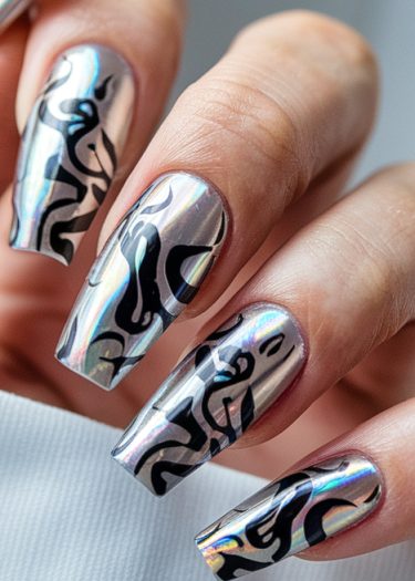 Stunning metallic chrome nails with intricate black abstract designs for modern nail art inspiration.