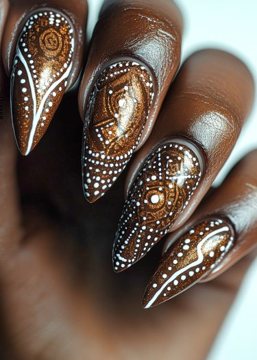 Stiletto metallic copper nail art with intricate white designs and shimmering details.