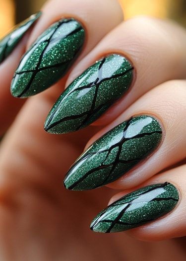 Exquisite metallic green nail art with intricate black cracked design on elegantly manicured hands.