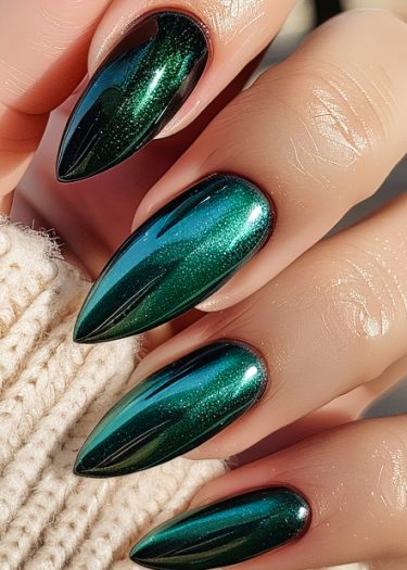 Stylish metallic green stiletto nails with glitter shine on a smooth hand.