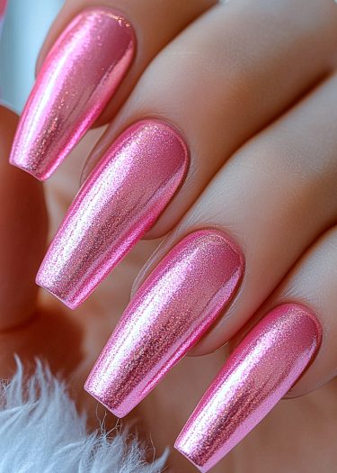 Impeccably manicured metallic pink coffin nails with shimmering iridescent polish and smooth cuticles.