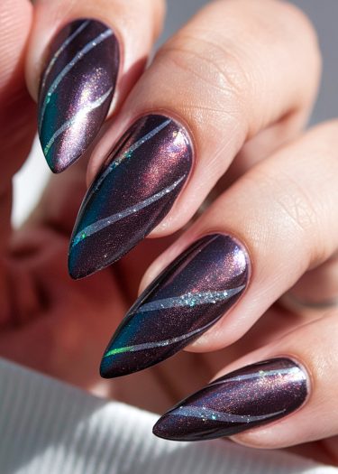 Elegant metallic purple nail art with iridescent stripes and glitter for a stunning look.