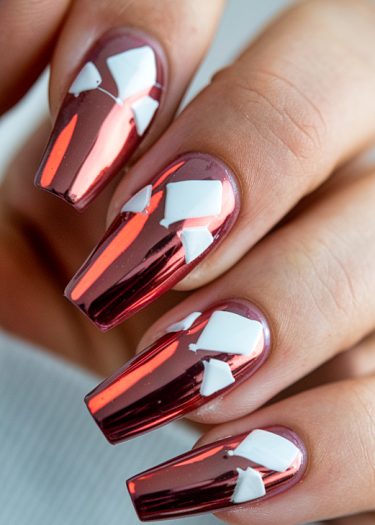 Stunning rose gold chrome coffin nails with bold white geometric designs for a fashionable manicure.