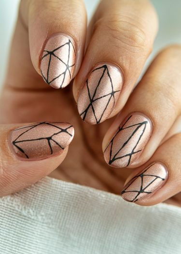 Elegant rose gold almond nails with geometric black designs, showcasing modern nail art style.