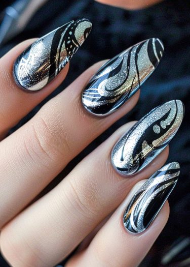 Elegant metallic silver nail art with intricate black and gold designs on long oval nails.