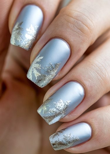 Elegant silver-blue matte nails with frosty metallic patterns for a chic winter look.