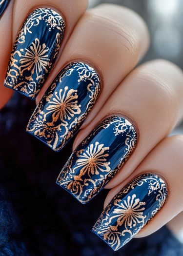 Intricate midnight blue and gold nail art featuring elegant floral designs for a sophisticated look.