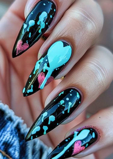 Elegant black almond nails with light blue splashes and pink hearts for a chic nail art design.