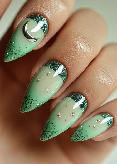 Elegant mint green gradient nails with glitter tips and celestial designs.