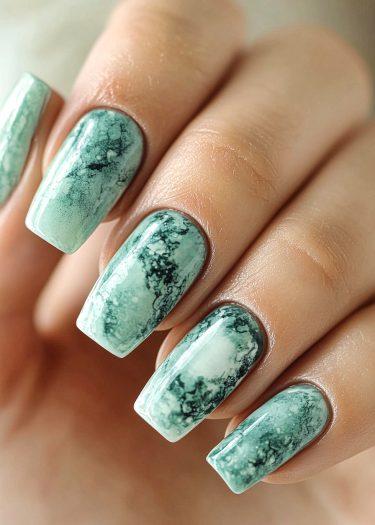 Elegant mint green marble nails with intricate swirling patterns and a glossy finish.