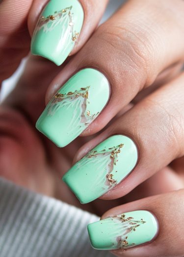 Elegant mint green marble nails with gold accents, showcasing intricate nail art design.