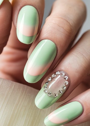 Elegant mint green nail art with diagonal stripes and rhinestone accents for a sophisticated look.