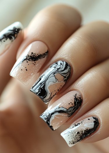 Elegant black and white marbled nail art with glitter on medium-length squared tips.