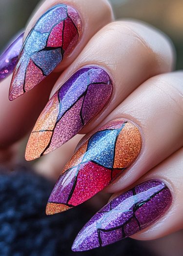 Stunning mosaic stained glass nail art in vibrant colors on stiletto-shaped nails.