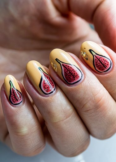 Mustard yellow nail art featuring detailed fig designs and sparkling glitter accents.