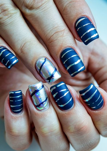 Stylish navy and silver nail art design with holographic accents for a chic look.