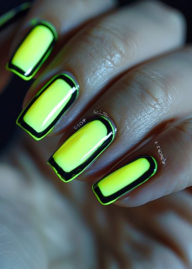 Vibrant neon yellow nail art with black outline, showcasing glossy, perfectly shaped nails.