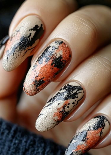 Elegant almond-shaped beige nail art featuring bold black and orange abstract designs.