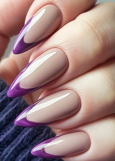 Almond-shaped nude nails with purple tips showcase modern French manicure elegance.