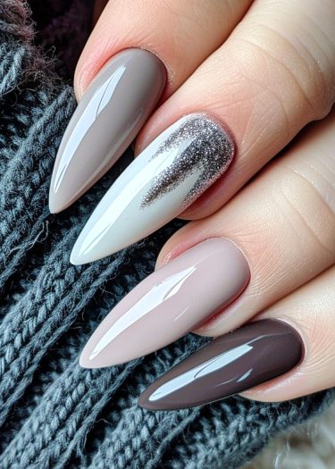 Elegant almond-shaped nails in neutral tones with glossy finishes and unique designs.