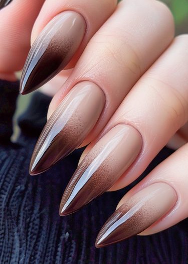 Stiletto nude-brown ombré nails with glossy finish, showcasing elegance and modern nail art design.