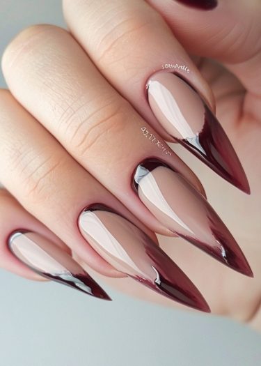 Gorgeous stiletto nails with nude and burgundy colors showcase elegant manicure artistry.