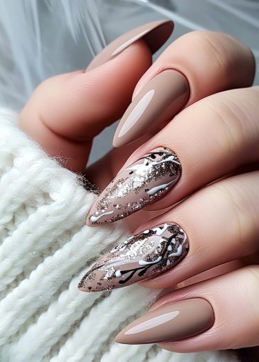 Elegant stiletto nails with nude matte finish and black glitter nail art design on a cozy background.