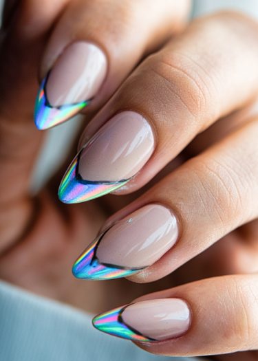 Impeccably manicured stiletto nails with nude base and holographic tips for a stylish look.