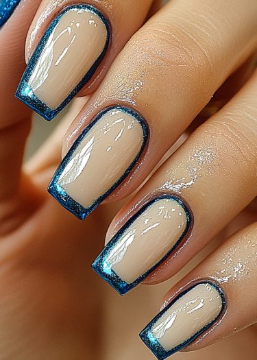 Elegant nude nails with metallic blue outline showcasing intricate nail art design.