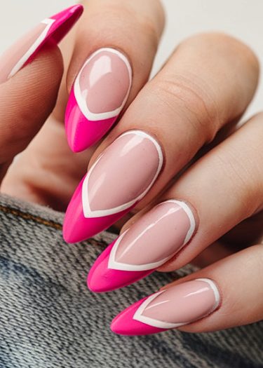 Stylish stiletto nails feature nude pink base with fuchsia tips and elegant white outline.