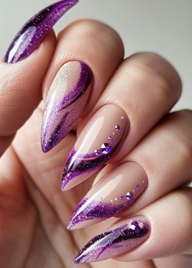 Stunning stiletto nails featuring nude, purple, and glitter designs with rhinestones for elegance.