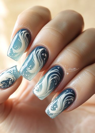 Manicured ocean wave nail art in blue and white, showcasing elegant and creative designs.