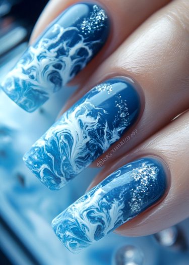 Stunning ocean wave nail art featuring deep blues and sparkling white accents for elegant nails.