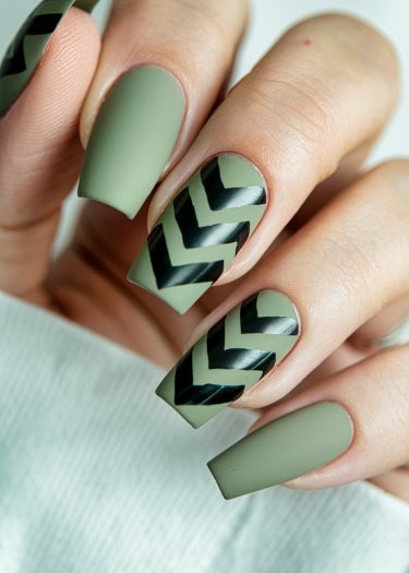 Sophisticated olive green matte nails with glossy black chevron design for a modern manicure.