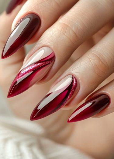 Elegant ombre red stiletto nails with glitter accents, perfect for sophisticated nail art enthusiasts.