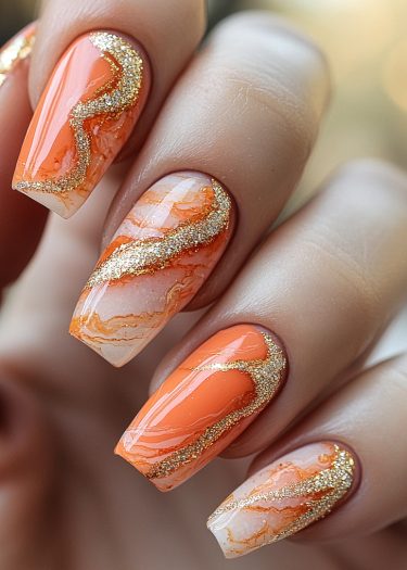 Stunning orange and white marble nail art with glitter accents for a luxurious look.