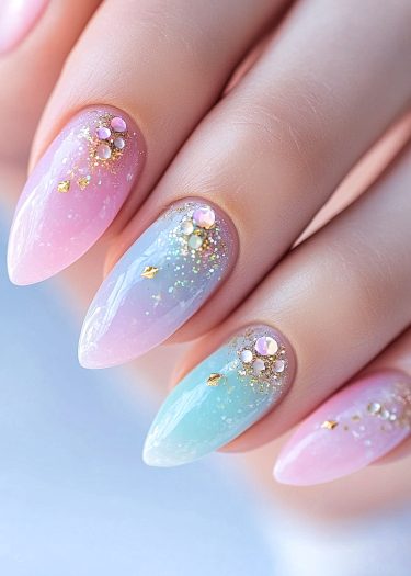 Elegant pastel almond nails with ombré effect and rhinestone embellishments for a chic look.