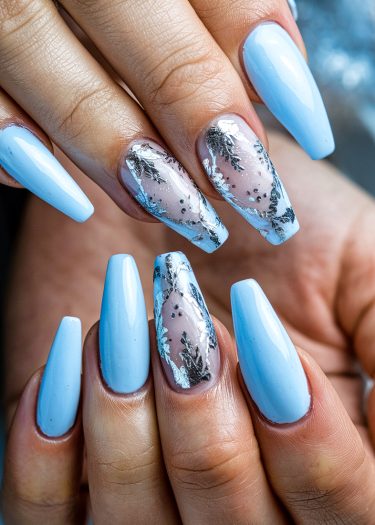 Elegant pastel blue almond nails with artistic silver foil designs for a chic manicure.