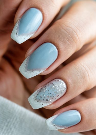 Elegant pastel blue manicure with ombre nails and a sparkling glitter accent design.