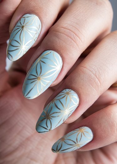 Elegant pastel blue nails with golden geometric patterns for sophisticated nail art inspiration.