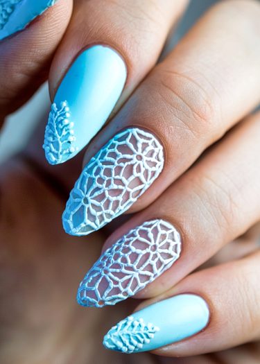 Elegant pastel blue lace nail art design with intricate patterns and delicate bead accents.