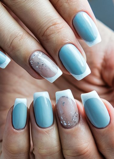 Stylish pastel blue and white French tips with glitter accents on manicured nails.