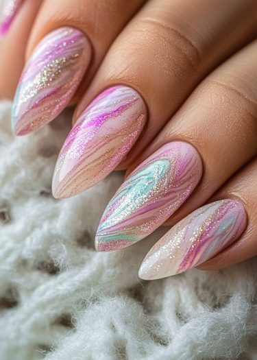 Elegant pastel glitter nail art with marble effect and almond tips for sophisticated style.