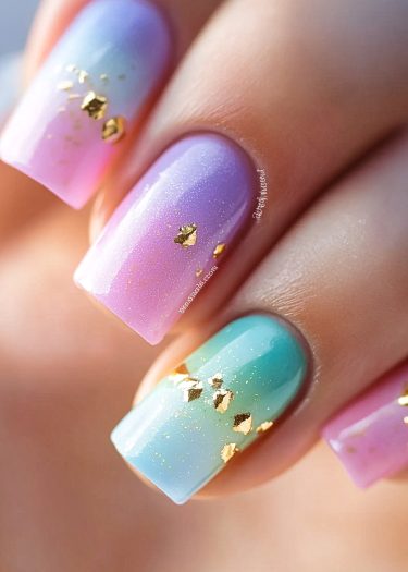 Elegant pastel gradient nails with gold leaf accents for a sophisticated manicure look.