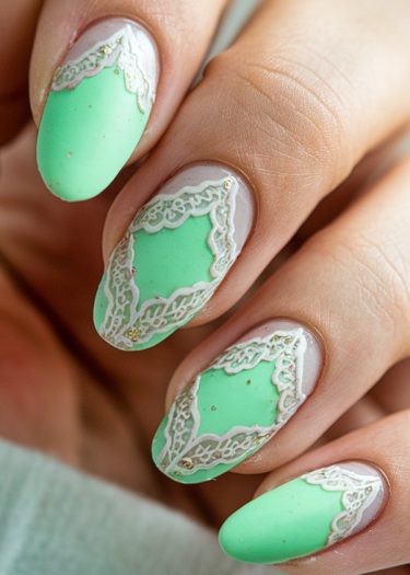 Elegant pastel green lace nail art design with gold accents on almond-shaped nails.